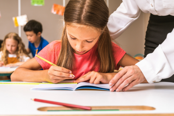 Dziewczyna w szkole pisząca w zeszycie